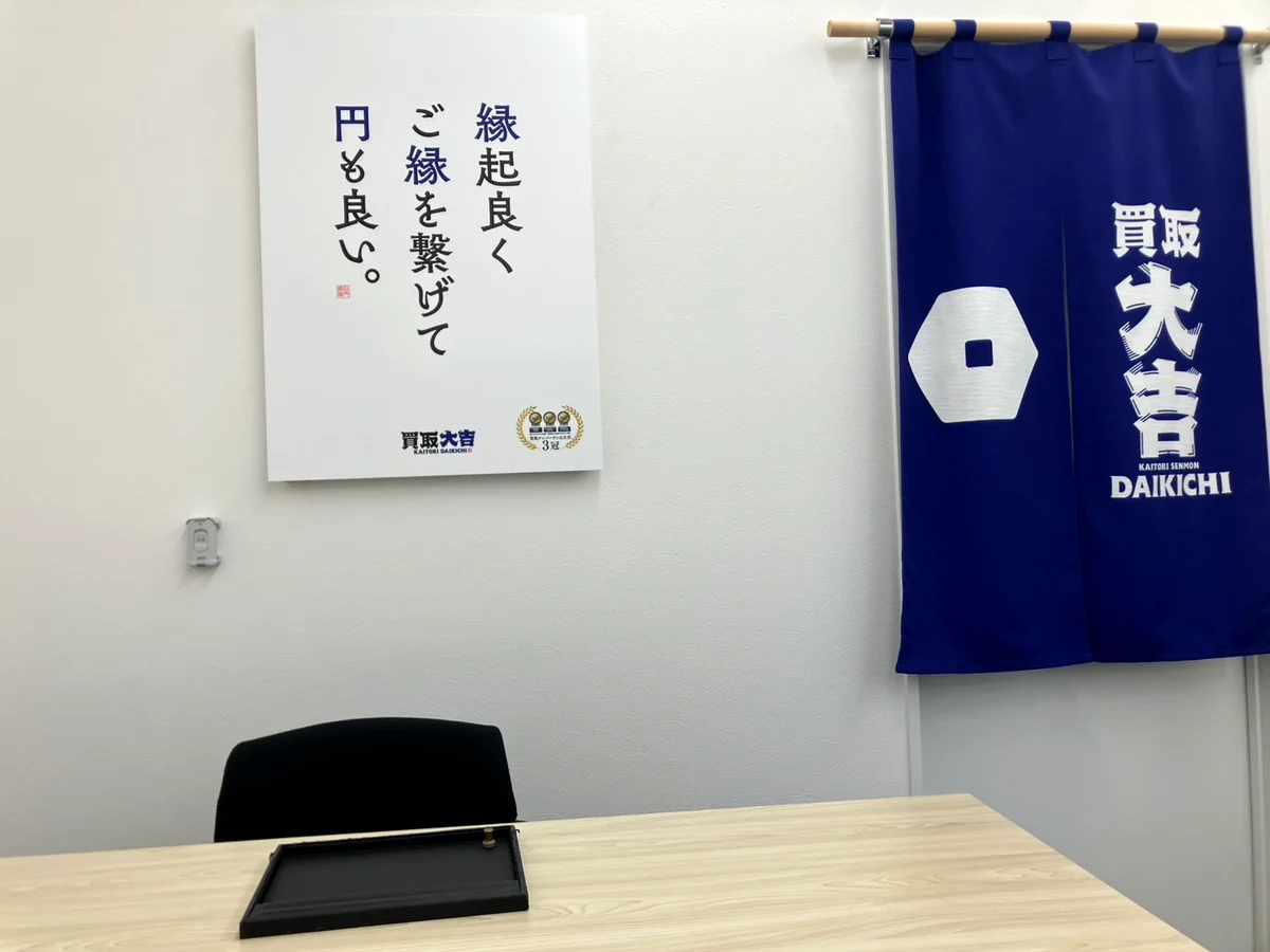 「縁起良く ご縁を繋げて 円も良い。」の掲示と暖簾のある査定ブース